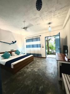 a bedroom with a bed and a large window at Atholhu Beach club in Fehendhoo