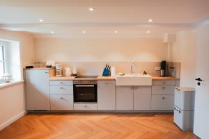 a kitchen with white cabinets and a sink at Ilsehof in Osterwieck