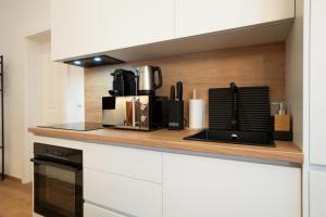 een keuken met een koffiezetapparaat op een aanrecht bij Bright, modern and central flat with a terrace in Wenen