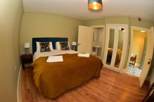 a bedroom with a large bed with two towels on it at Upper Yard Borris House in Borris