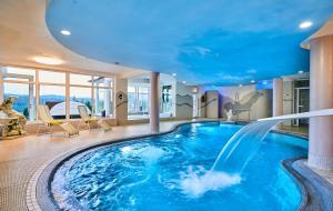 una piscina con scivolo d'acqua in una camera d'albergo di Richterhof Wellness Apartments Bayerischer Wald a Kollnburg