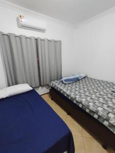 una camera con letto e finestra con tende di Hotel Indi a Ribeirão Preto