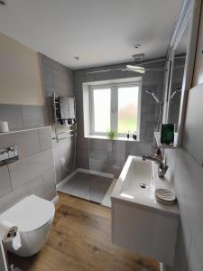 a white bathroom with a toilet and a sink at Clifton House in London