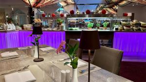 a restaurant with a table with purple lighting at Hotel & SPA Sommerfeld - Adults Only in Kremmen