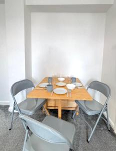 una mesa de madera con 4 sillas alrededor en City Central Panoramic Apartment, en Londres