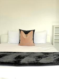 Una cama con dos almohadas y una manta. en City Central Panoramic Apartment, en Londres