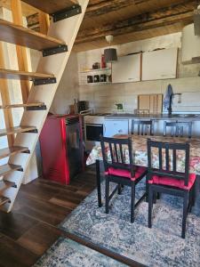 a kitchen with a table and two chairs and a red refrigerator at Art Village in Kremna