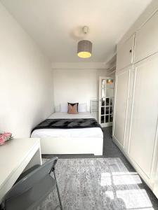 1 dormitorio con 1 cama blanca en una habitación en City Central Panoramic Apartment, en Londres