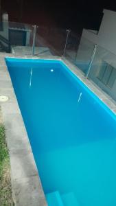 a blue swimming pool in front of a building at Casa en cineguilla in Cieneguilla