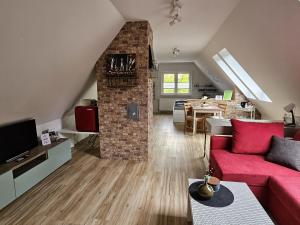 a living room with a red couch and a brick wall at Loft- Privatzimmer 30qm im Dachgeschoss mit eigenem Bad in Ahaus