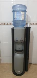 un enfriador de agua con un contenedor azul encima en Apartamentos Camino Inglés, en Ordes