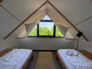 a room with two beds and a window at Domki Kuter Port in Gdów