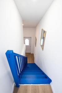Una escalera azul en una habitación blanca con una escalera azul en Casa Azul - Belle maisonnette colorée - Garibaldi, en Lyon