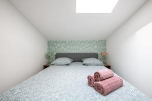 - une chambre avec un lit et 2 oreillers roses dans l'établissement Casa Azul - Belle maisonnette colorée - Garibaldi, à Lyon