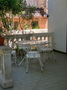 un tavolo e sedie seduti su un patio di Villa Strazzeri a Palermo