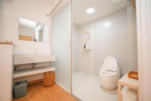 La salle de bains est pourvue de toilettes et d'une douche en verre. dans l'établissement Leye Inn, à Yangshuo