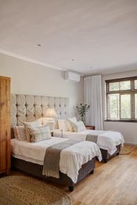 twee bedden in een grote slaapkamer met witte muren bij Minserie Collection in Stellenbosch