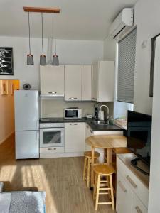 een keuken met witte apparatuur en een houten tafel bij Apartments Ines - cozy studio in Zagreb