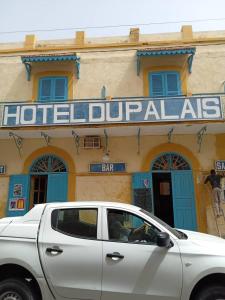 a white car parked in front of a hotel durgas at HOTEL DU PALAIS in Saint-Louis