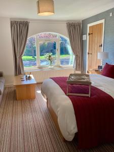 a hotel room with a large bed and a window at The Garden Suites at Snape Castle Mews in Bedale