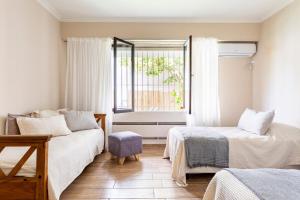 Habitación con 2 camas, ventana y sofá en Casa Noble en Mendoza