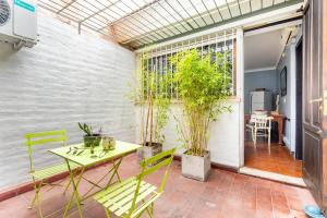 patio con mesa, sillas y ventana en Casa Noble en Mendoza