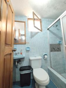 a bathroom with a toilet and a sink and a shower at Hotel Rosim Cotopaxi in Latacunga