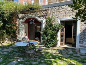 卡普里Luna tu Capri casa vacanze的一间带门的石屋前的一张桌子