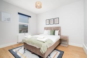 a bedroom with a large bed and a window at 2 bedroom flat near Tottenham Hotspur Stadium in London