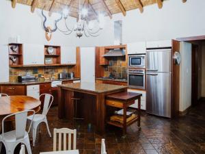 cocina con mesa y nevera de acero inoxidable en Bona Bona Game Lodge, en Wolmaranstad