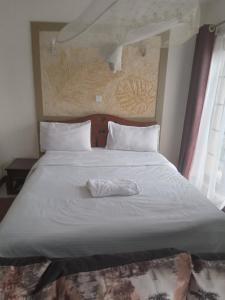 Una cama con una toalla blanca encima. en Mvuli suites en Nairobi