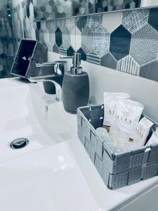 a bathroom sink with a basket of toiletries on it at La Casa di NAra in Naples +32 photos