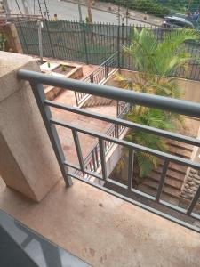 a metal railing on a balcony with a palm tree at Mvuli suites in Nairobi