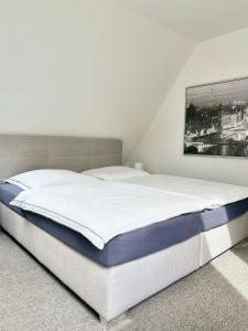 1 cama en un dormitorio con una foto en la pared en Heide Apartments, en Schneverdingen