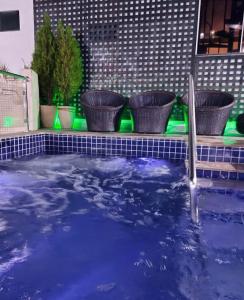 uma banheira de hidromassagem com água azul e três plantas em THERMAS DO BANDEIRANTE em Caldas Novas