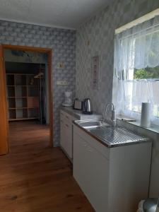 eine Küche mit einer Spüle und einer Arbeitsplatte in der Unterkunft Ferienwohnung Reepschläger in Papendorf
