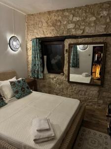 een slaapkamer met een groot bed en een spiegel bij The Little Stone House - Küçük Taş Ev in Kyrenia