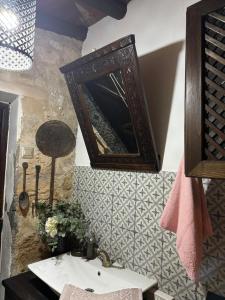 een badkamer met een wastafel en een spiegel aan de muur bij The Little Stone House - Küçük Taş Ev in Kyrenia