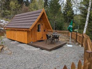 a large wooden cabin with a table and a flag at Klosterweiherhof in Dachsberg im Schwarzwald