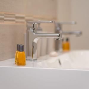 a bathroom sink with a bottle of soap on the counter at Séjour romantique, Massif central in Bort-les-Orgues +5 photos