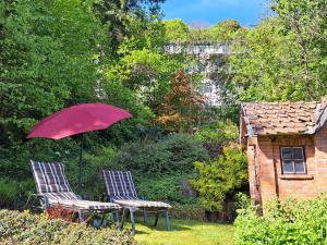 バート・ゾーデン・アレンドルフにあるHaus Lieberumの庭の椅子2脚と赤い傘