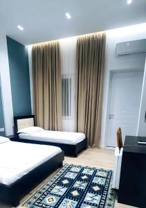 - une chambre d'hôtel avec 2 lits et un tapis dans l'établissement VILA LILI Guest House - Berat, à Berat