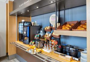 eine Bäckerei mit einer Theke mit Gebäck und einem Café in der Unterkunft B&B HOTEL Dunkerque Centre Gare in Dunkerque