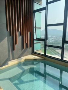 a room with a swimming pool in front of a window at Seaview condo in Siracha (Free onzen) in Si Racha