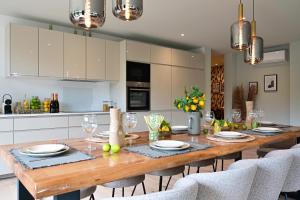 cocina con mesa de comedor de madera y sillas en Extraordinaire Villa 5 étoiles 12 personnes 7 min Lille en Marcq-en-Baroeul