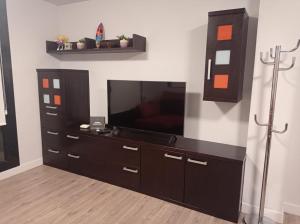 ein Wohnzimmer mit einem TV und einem schwarzen Entertainment-Center in der Unterkunft Apartamento Vive Jaca in Jaca