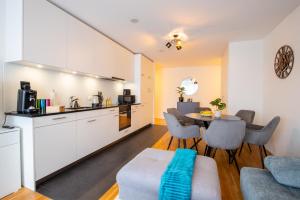 eine Küche und ein Wohnzimmer mit einem Tisch und Stühlen in der Unterkunft Special EiNSTEiN II Apartment Basel, Messe Kleinbasel 10-STAR in Basel