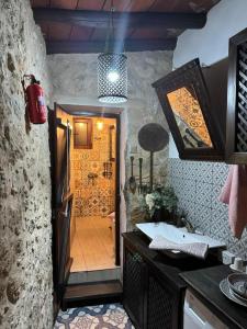 een keuken met een wastafel en een deur naar een badkamer bij The Little Stone House - Küçük Taş Ev in Kyrenia