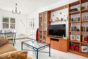 a living room with a tv and a glass table at Reliquia 3 in Novo Sancti Petri