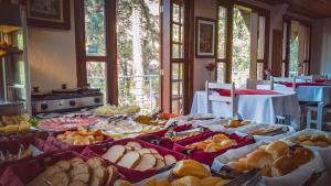 a table filled with lots of different types of food at Pousada Atalaia Capivari in Campos do Jordão